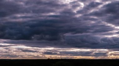 Ufukta hareket eden dramatik fırtına bulutlarının zamanı. Kara fırtınalı kümülüs bulutları bulut uzayında şekillerini değiştirir. Dramatik atmosfer geçmişi, zaman atlaması. Hava değişimi. Manzara gökyüzü