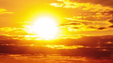 Dramatic sunset with sun rays in the Sky through orange layered clouds, Timelapse. The big bright orange sun with sun rays moves down over the horizon. Awesome epic cloud space. Time Lapse. Sundown