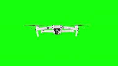 Real quadcopter with camera flights on a green screen. A drone hovering in the air with an alpha channel. Isolated portable copter on alpha matte. Aircraft blades rotate in hanging. Alpha channel 4K