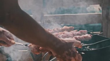 Doğadaki ızgarada şiş ızgarada barbekü yapmak. Terbiye edilmiş kebap mangal kömüründe kızartılır. Güneşli bir günde sahilde barbekü pişirme işlemi. BBC 'deki metal şişte lezzetli yemekler. Şişler açık