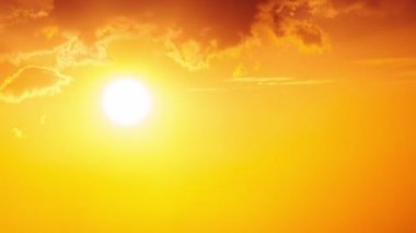 Dramatic sunset with sun rays in the Sky through orange layered clouds, Timelapse. The big bright orange sun with sun rays moves down over the horizon. Awesome epic cloud space. Time Lapse. Sundown
