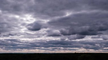 Ufukta hareket eden dramatik fırtına bulutlarının zamanı. Kara fırtınalı kümülüs bulutları bulut uzayında şekillerini değiştirir. Dramatik atmosfer geçmişi, zaman atlaması. Hava değişimi. Manzara gökyüzü