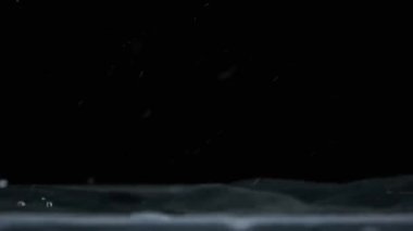 Yavaş çekimde suyun yüzeyine çok su damlası düşer, makro çekim. Damlalar sıvı yüzeyi vurarak dalgalar, daireler ve sıvı türbülans oluşturur. Yüzey gerilimi. 240 fps.