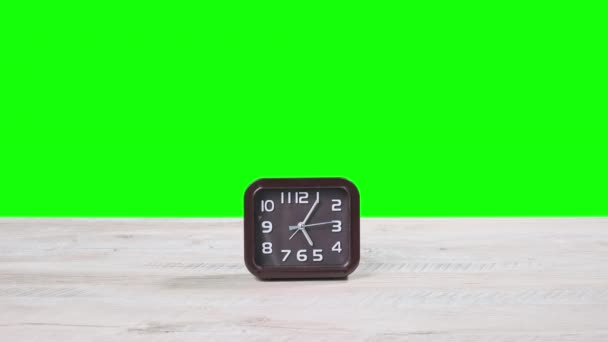 木制桌子上的模拟时钟显示绿色屏幕上的时间 二手移动的圆形棕色拨号盘的方形机械手表的特写 时间管理 日常事务 — 图库视频影像