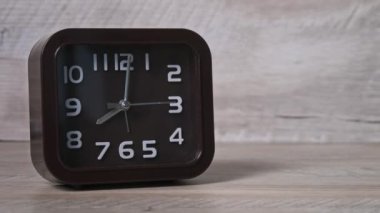 Tahta masadaki işaret saati 8 oktanlı saati gösteriyor. Kare şeklinde oklu kahverengi saat, ikinci, dakika, saat başı yakın çekim. Mekanik modern saat. Kavram çizelgesi, erken kalkış, günlük rutin
