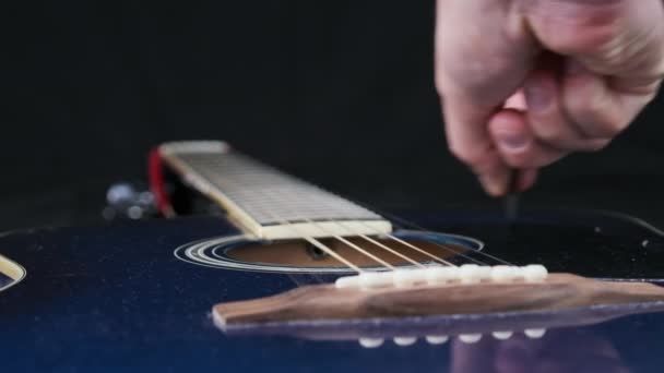 スローモーションでアコースティックギターの弦の振動 クラシックギターメタルの弦はメディエーターに触れながら振動する スロームーブメント120Fps クローズアップギターデッキ ギタリストがブロンズ弦に触れる — ストック動画
