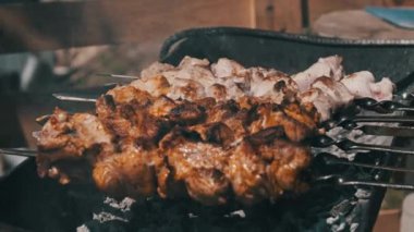 Process of cooking delicious shish kebab on metal skewer in summer outdoors. Grilling shashlik on barbecue grill. Marinated kebab is grilled on charcoal. Skewers on skewers. Weekend picnic Street food