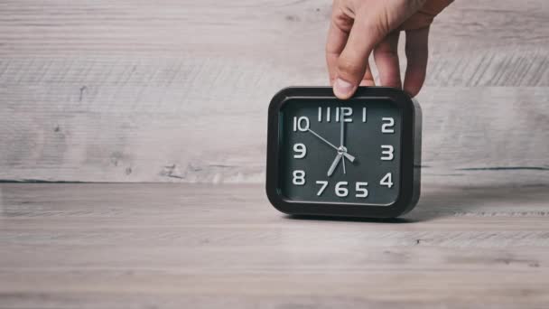 方形的尖褐色钟表在木制桌子上显示时间 男性的手把箭头机械手表放在桌上 二手移动沿着圆盘 概念时间表 日常活动 — 图库视频影像