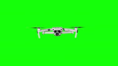 Real quadcopter with camera flights on a green screen. A drone hovering in the air with an alpha channel. Isolated portable copter on alpha matte. Aircraft blades rotate in hanging. Alpha channel 4K