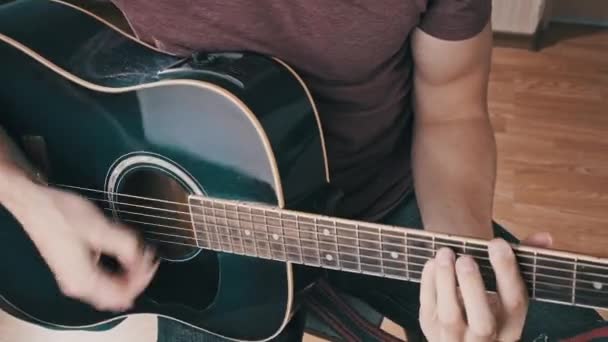 연주자는 온라인 학습을 기타를 남자는 프렛의 화음을 맞추고 노래를 부른다 — 비디오