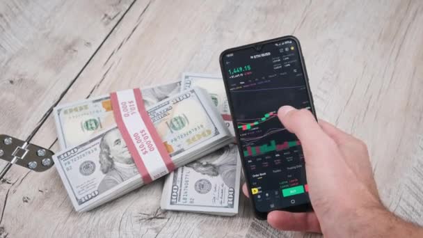 Trader Analyseert Ethereum Cryptogeld Prijzen Een Smartphone Scherm Boven Een — Stockvideo