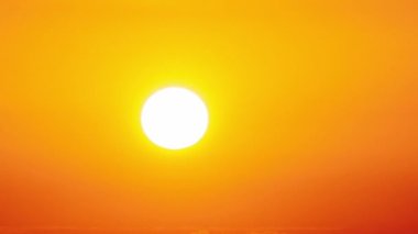 Dramatic sunset with sun rays in the Sky through orange layered clouds, Timelapse. The big bright orange sun with sun rays moves down over the horizon. Awesome epic cloud space. Time Lapse. Sundown