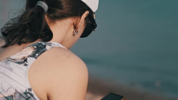 Menina Bonita Maiô Senta Uma Praia Areia Com Telefone Suas — Vídeo de Stock