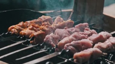 Process of cooking delicious shish kebab on metal skewer in summer outdoors. Grilling shashlik on barbecue grill. Marinated kebab is grilled on charcoal. Skewers on skewers. Weekend picnic Street food