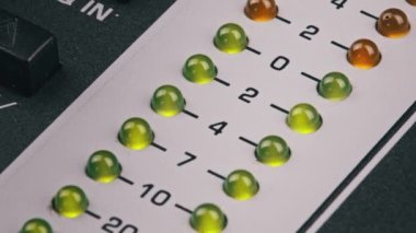 LED indicator of sound level signal on the mixing console. LED strip in green and yellow on output level indicator. Volume level changes of indicator lights. VU meters on the analog sound desk. Macro
