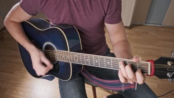 연주자는 집에서 어쿠스틱 기타를 남자는 프렛의 화음을 맞추고 노래를 부른다 — 비디오