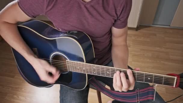 吉他手在家里弹吉他 那个人把和弦弹奏在琴弦上 然后放这首歌 学习弹古典吉他 年轻的音乐家在客厅里弹奏吉他 — 图库视频影像