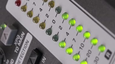 Karıştırma konsolunda ses seviyesi sinyalinin dikey video LED göstergesi. VU çıkış göstergesinde yeşil ve sarı şeritli yakın çekim. Ses düzeyi ampulleri değişiyor. Stereo ölçerler