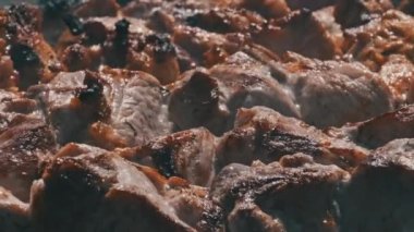 Process of cooking delicious shish kebab on metal skewer in summer outdoors. Grilling shashlik on barbecue grill. Marinated kebab is grilled on charcoal. Skewers on skewers. Weekend picnic Street food