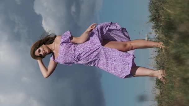 Pionowy Wolny Ruch Atrakcyjnej Kobiety Fioletowej Sukience Słomkowym Kapeluszu Spaceruje — Wideo stockowe