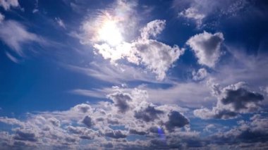 Mavi gökyüzünde güneşin altında hareket eden tüylü bulutların zamanı. Bulut uzayı arka planı. Muhteşem cennette kümülüs bulutlarının zaman akışı. Manzaralı atmosfer. Hava değişikliği. Doğa. 4K