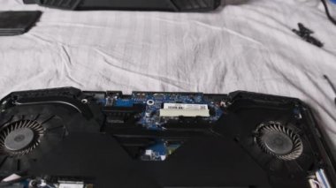 Laptop tamir servisi. Kırık dizüstü bilgisayar, radyo şefinin masasında yatıyor. Ana kart, soğutma vantilatörleri ve radyo parçaları bir dizüstü bilgisayarın içinde. Bilgisayar ekipmanlarının bakımı. Bilgisayar onarım servisi