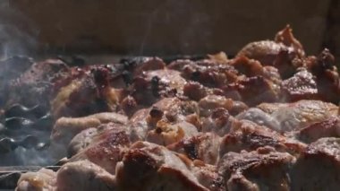 Process of cooking delicious shish kebab on metal skewer in summer outdoors. Grilling shashlik on barbecue grill. Marinated kebab is grilled on charcoal. Skewers on skewers. Weekend picnic Street food