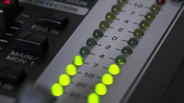 LED indicator of sound level signal on the mixing console. LED strip in green and yellow on output level indicator. Volume level changes of indicator lights. VU meters on the analog sound desk. Macro