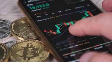 Yatırımcı akıllı telefon ekranındaki kripto para birimini kontrol ediyor. Şifreli paralarla telefon ekranında kripto ticareti. İşadamı, dijital borsa yatırımlarını inceliyor. Bitcoin fiyatı BTC Pazarı