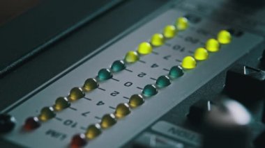 LED indicator of sound level signal on the mixing console. LED strip in green and yellow on output level indicator. Volume level changes of indicator lights. VU meters on the analog sound desk. Macro