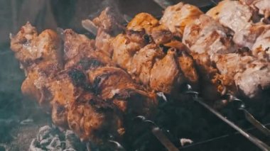 Process of cooking delicious shish kebab on metal skewer in summer outdoors. Grilling shashlik on barbecue grill. Marinated kebab is grilled on charcoal. Skewers on skewers. Weekend picnic Street food