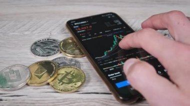 Yatırımcı akıllı telefon ekranındaki kripto para birimini kontrol ediyor. Şifreli paralarla telefon ekranında kripto ticareti. İşadamı, dijital borsa yatırımlarını inceliyor. Bitcoin fiyatı BTC Pazarı