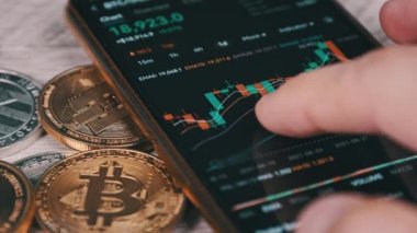 Şifreli akıllı telefon ticareti. İşadamı şifreli paralarla birlikte dijital borsada kripto fiyat tablosunu kontrol ediyor. BTC fiyatı. Kripto para ticareti. Çevrimiçi piyasa, değişim grafiği, Bitcoin