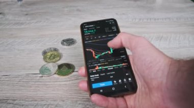 Şifreli akıllı telefon ticareti. İşadamı şifreli paralarla birlikte dijital borsada kripto fiyat tablosunu kontrol ediyor. BTC fiyatı. Kripto para ticareti. Çevrimiçi piyasa, değişim grafiği, Bitcoin