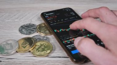 Yatırımcı akıllı telefon ekranındaki kripto para birimini kontrol ediyor. Şifreli paralarla telefon ekranında kripto ticareti. İşadamı, dijital borsa yatırımlarını inceliyor. Bitcoin fiyatı BTC Pazarı