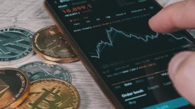 İşadamı şifreli paralarla birlikte dijital borsada kripto fiyat tablosunu kontrol ediyor. BTC fiyatı. Şifreli akıllı telefon ticareti. Kripto para ticareti. Çevrimiçi piyasa, değişim grafiği, Bitcoin
