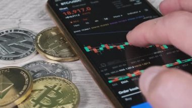 İşadamı şifreli paralarla birlikte dijital borsada kripto fiyat tablosunu kontrol ediyor. BTC fiyatı. Şifreli akıllı telefon ticareti. Kripto para ticareti. Çevrimiçi piyasa, değişim grafiği, Bitcoin