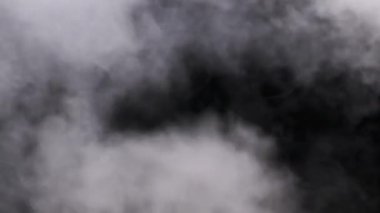 Gerçek patlama buharı ya da duman bulutları ağır çekimde yükselir, kompozit ve video düzenleme için kullanılır. Özel efekt, doku. Siyah arka planda duman bulutu var. Buharın soyut parçacıkları
