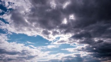 Mavi gökyüzünde, güneşin altında hareket eden bulutlar, hızlandırılmış zaman. Bulut uzayı arka planı. Muhteşem cennette kümülüs bulutlarının zamanı. Manzaralı atmosfer. Hava değişikliği. Doğa. 4K