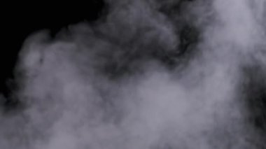 Gerçekçi duman veya buhar bulutları yavaş çekimde yükselir, kompozit ve video düzenleme için kullanılır. Özel efekt, doku. Siyah arka planda duman bulutu var. Buharın soyut parçacıkları