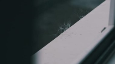 Yağmur damlaları pencerenin kenarına ağır çekimde vuruyor. Yağmurlu bir günde yağmur damlaları pencere kenarına düşer, ağır çekimde. Fırtına sırasında pencere pervazı, yakın çekim. Gri bir havayla sonbahar yağmuru. Sonbahar melankolisi
