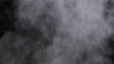 Gerçekçi duman veya buhar bulutları yükselir, kompozit ve video düzenleme için kullanılır. Özel efekt, doku, görüntü. Siyah arka planda duman bulutu var. Buhar dokusunun soyut parçacıkları. 4K
