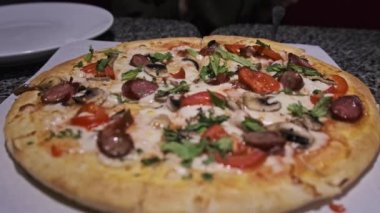 Restorandaki masada taze pizza var. Pizzacının iştah açıcı pizzasından bir dilim. 4K