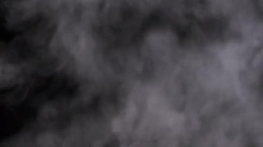 Siyah arka planda beyaz duman. Bir buhar bulutu yükseliyor. Yüzen sis. Buhar buharı patlaması. Şeffaf duman bulutları, soyut sis, buhar dokusu. Gerçek atmosferik etki. 4K.
