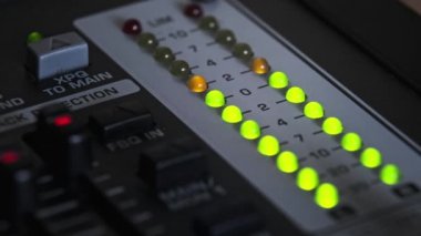 LED indicator of sound level signal on the mixing console. Close-up shot of strip in green and yellow on VU output level indicator. Volume level changes of indicator bulbs. Stereo meters on a soundbar