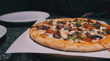 Restorandaki masada taze pizza var. Pizzacının iştah açıcı pizzasından bir dilim. 4K