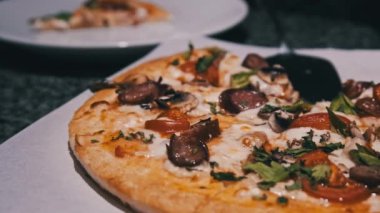 Restorandaki masada taze pizza var. Pizzacının iştah açıcı pizzasından bir dilim. 4K