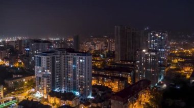 Multistorey Buildings with Changing Window Lighting At Night in City. Timelapse. Time lapse of City Space with Modern Skyscrapers, slums, and Construction Site. The light in the windows is turned on