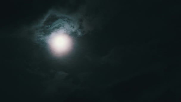 夜空に満月の暗い雲 タイムラプスを介して移動します 雲を背景に神秘的な明るい月が浮かび上がる 月明かりが夜空に輝きます 時間の経過 — ストック動画
