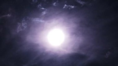 Gece gökyüzündeki dolunay kara bulutların arasında hareket eder, Timelapse. Mistik parlak ay bulutların arka planına doğru yükseliyor. Ay ışığı karanlık gece gökyüzünde parlar. Ayın doğumu zaman aşımı. 4K